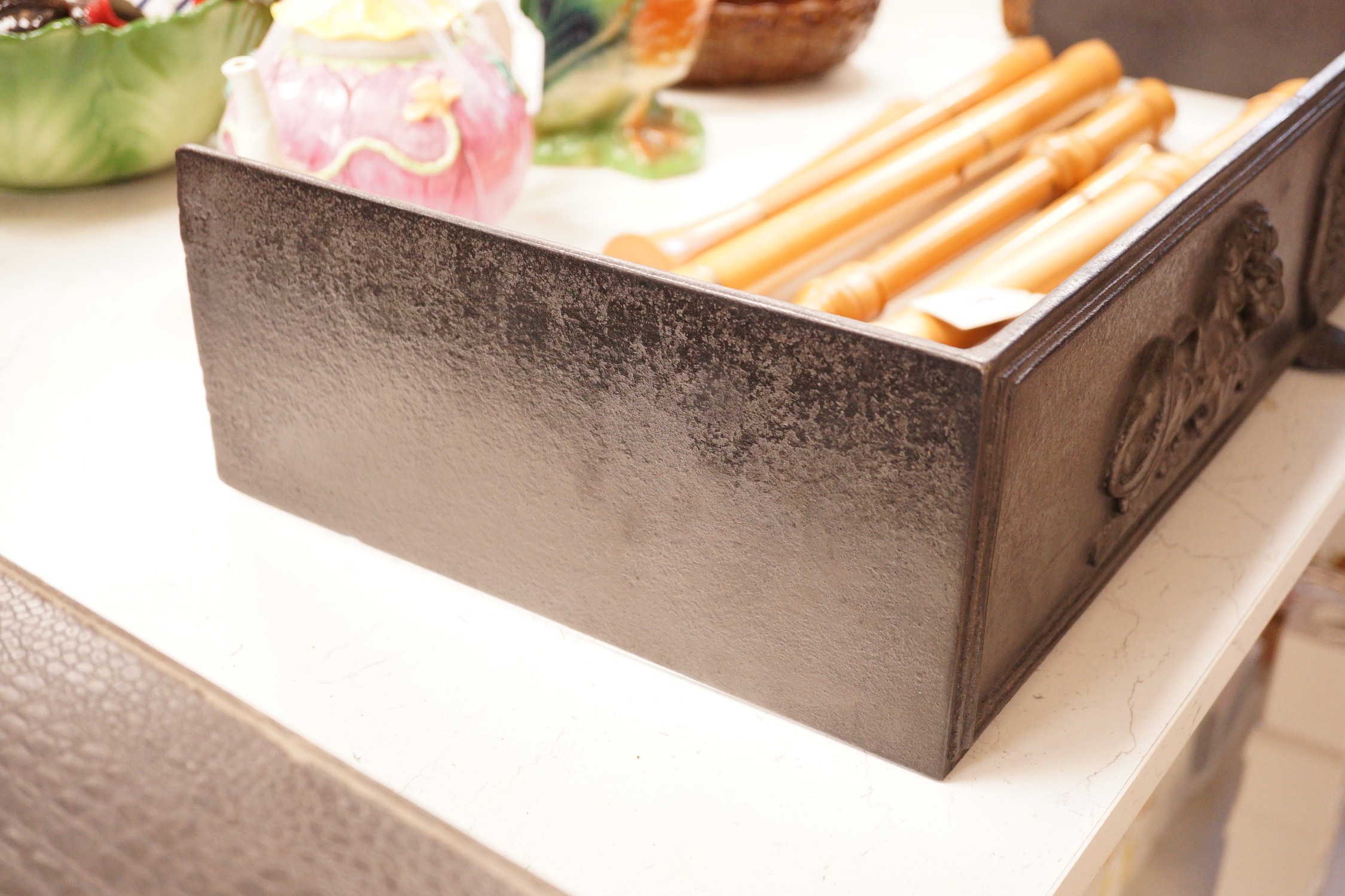A blackened cast iron fender, of rectangular form decorated with lions, 76.5cm wide, 31cm deep